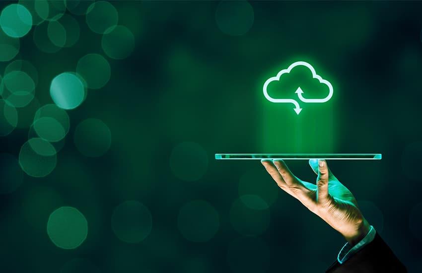 Hand holding a tablet with a neon cloud symbol above it