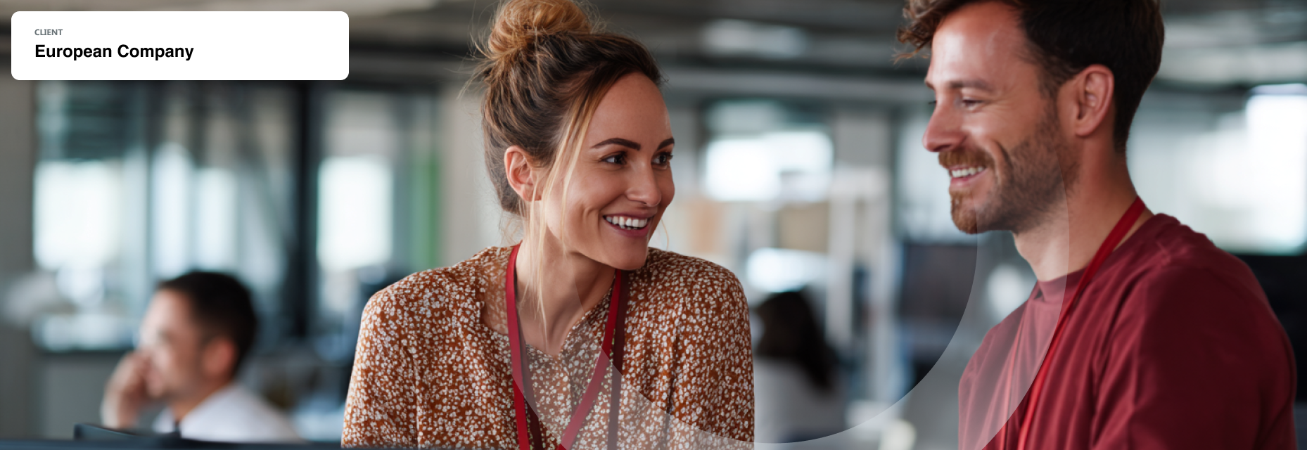 Professionals smiling and collaborating, modern office and colleagues blurred in the background.