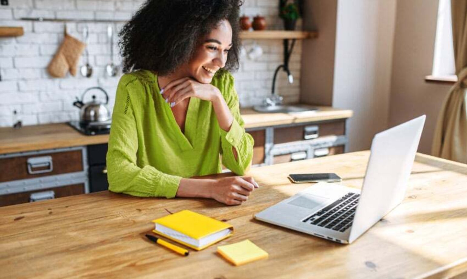Eine Frau, die lächelt, während sie an einem Laptop mit Windows 11 arbeitet